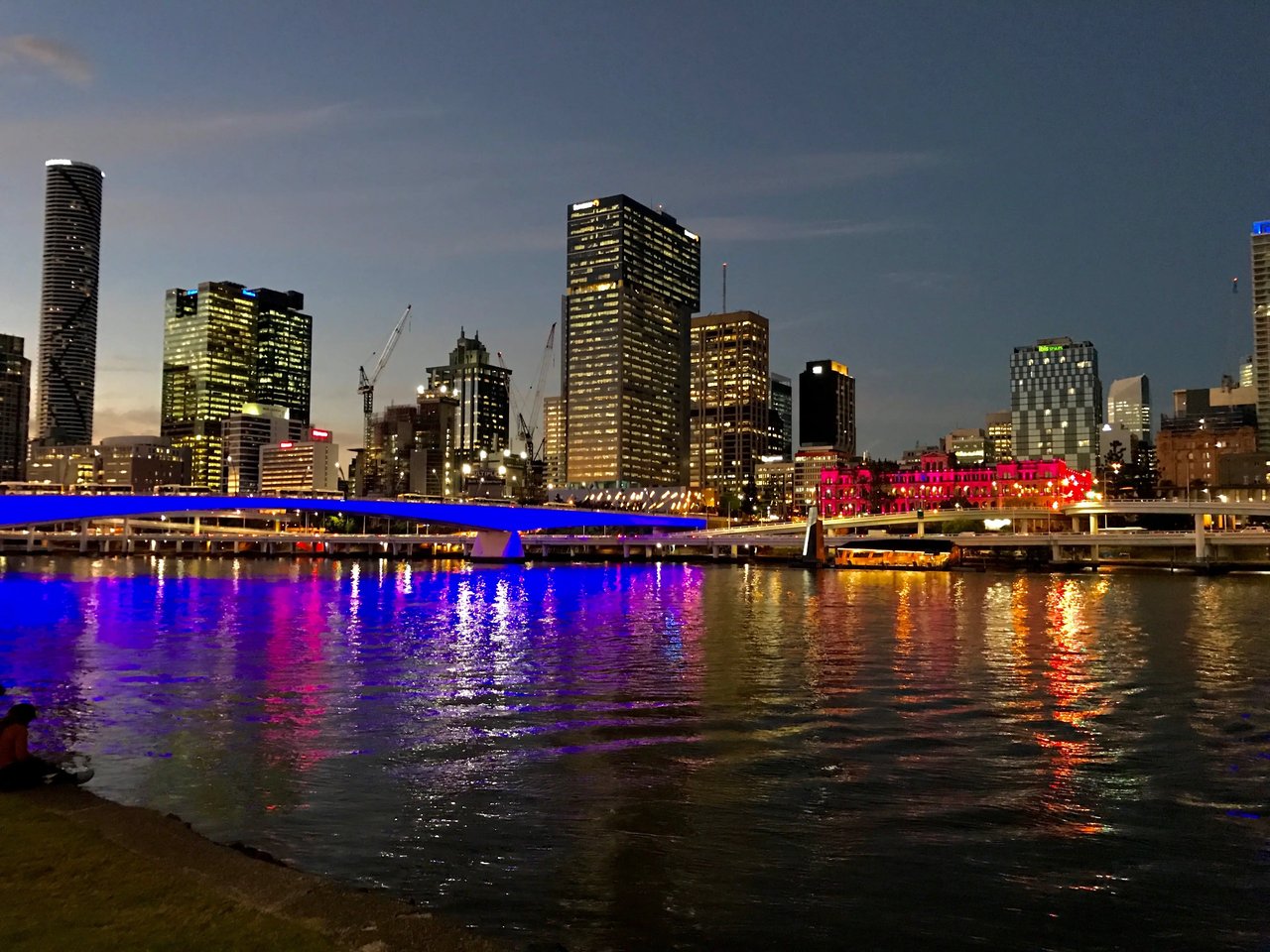 Skyline von Brisbane bei Nacht mit beleuchteten Gebäuden.