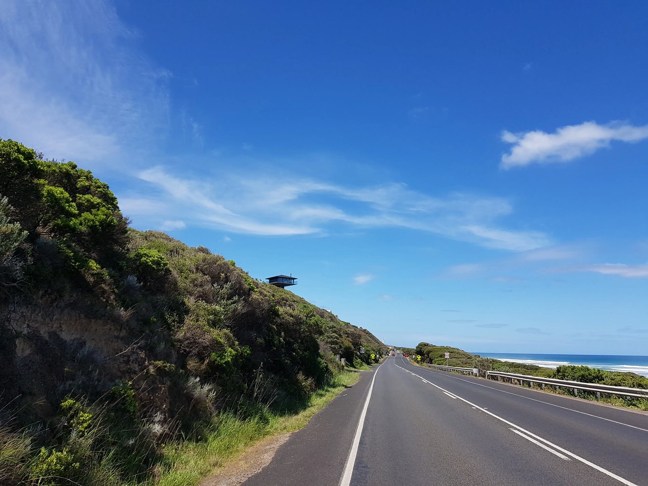 Küstenstraße in Australien mit blauem Himmel während eines Roadtrips.