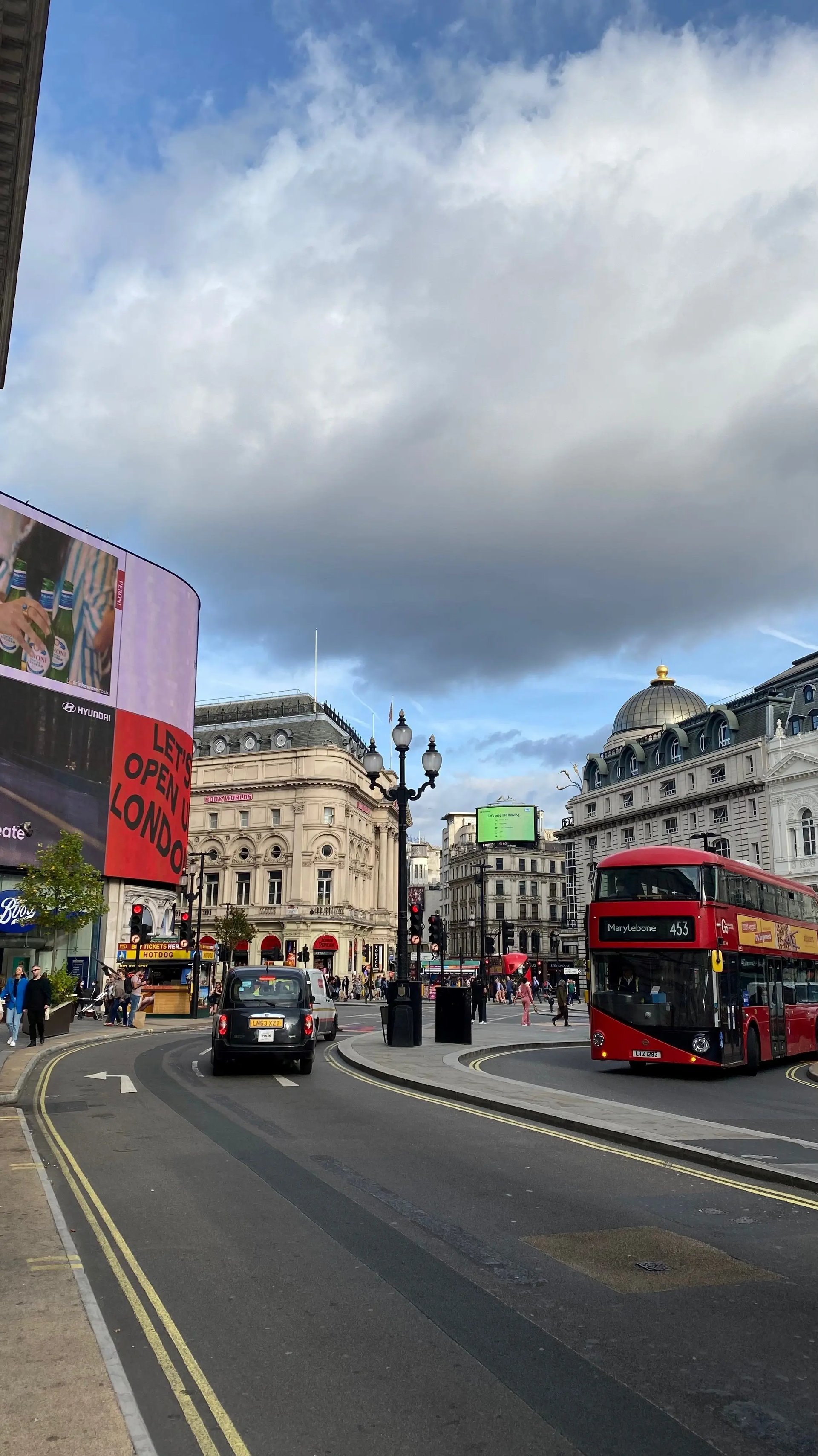 Piccadilly Circus in London mit rotem Doppeldeckerbus und Werbetafeln.