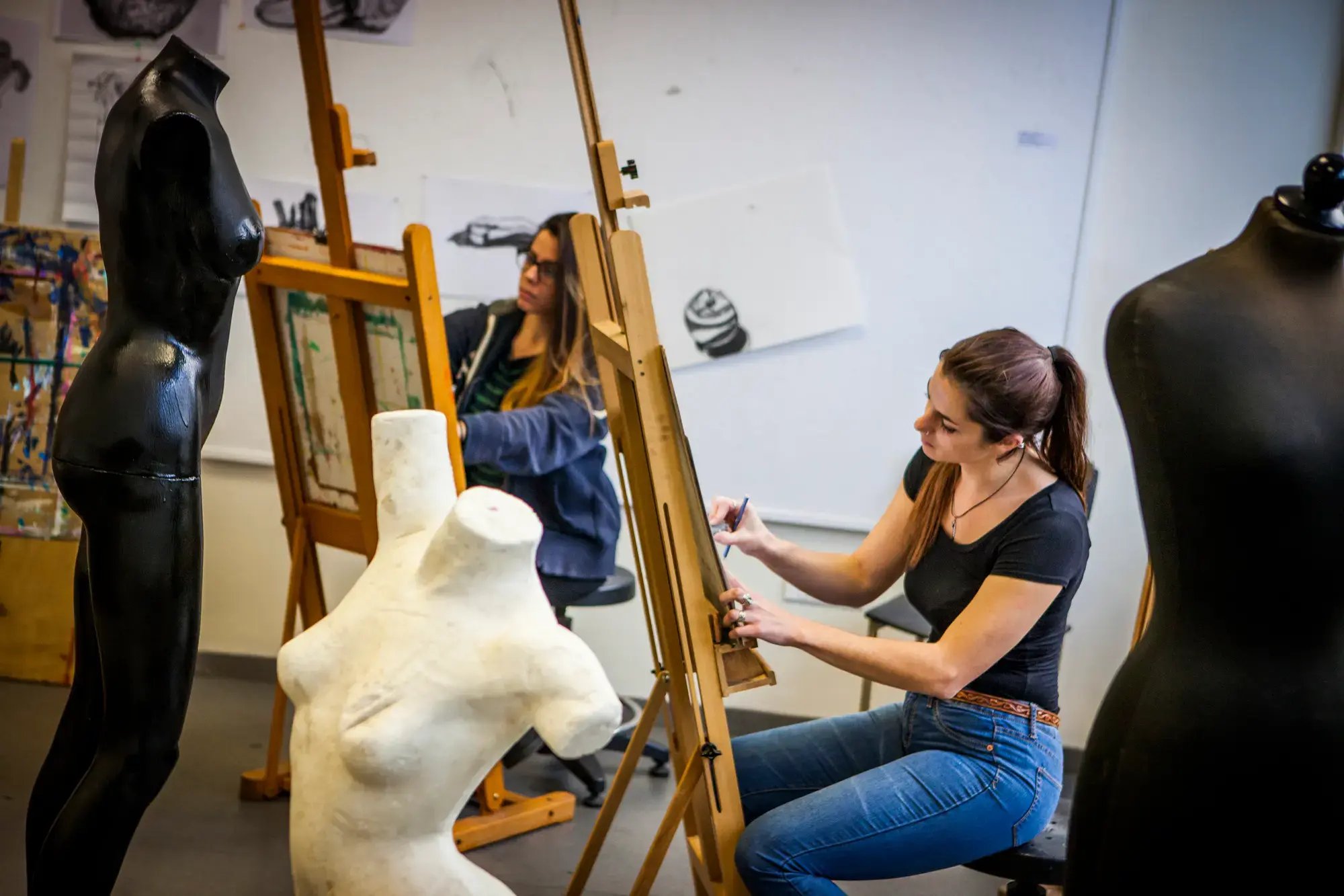 Studentin zeichnet eine Torso-Skulptur im Kunstunterricht.