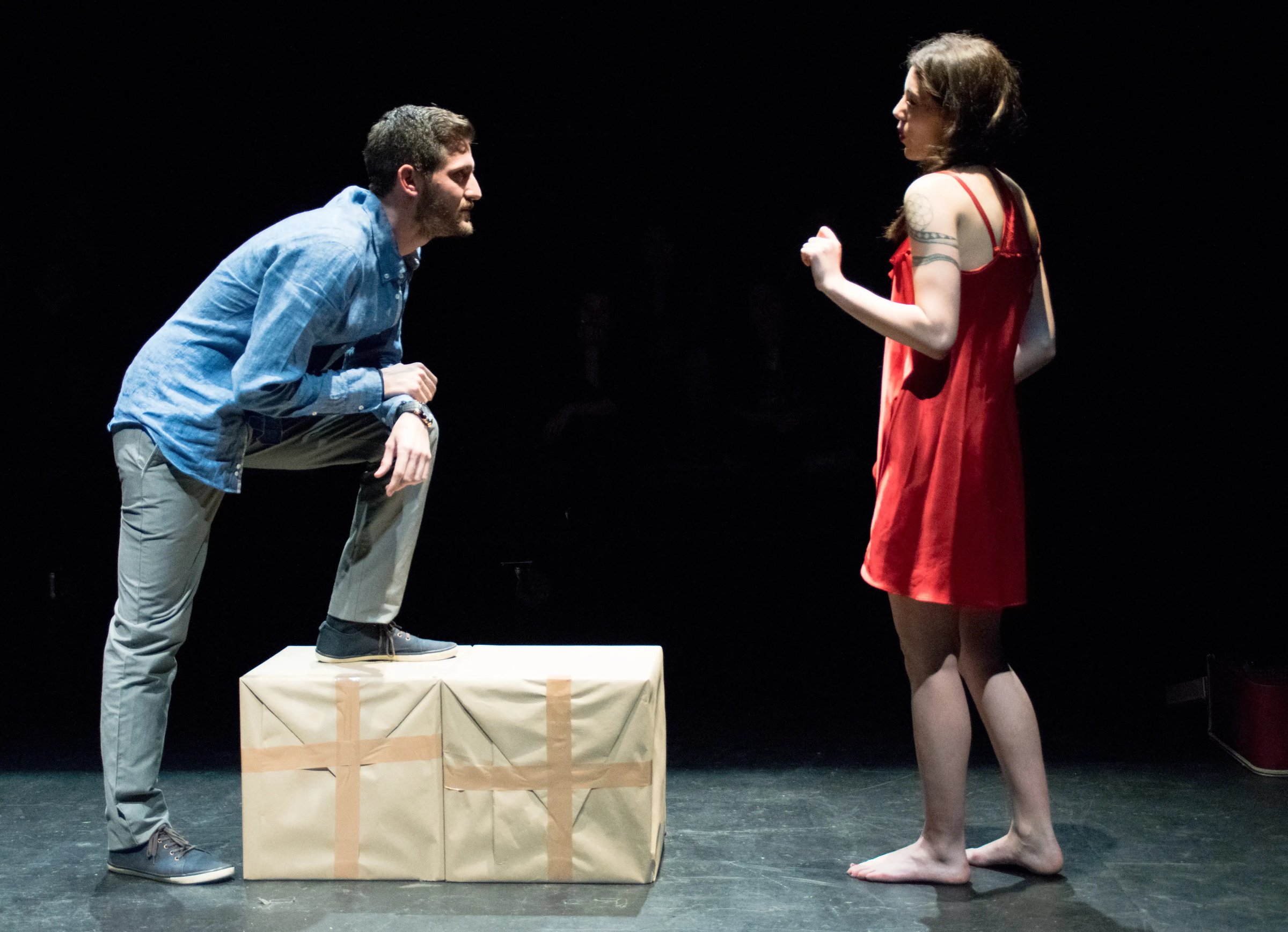 Zwei Studierende proben auf der Theaterbühne eine Szene. 