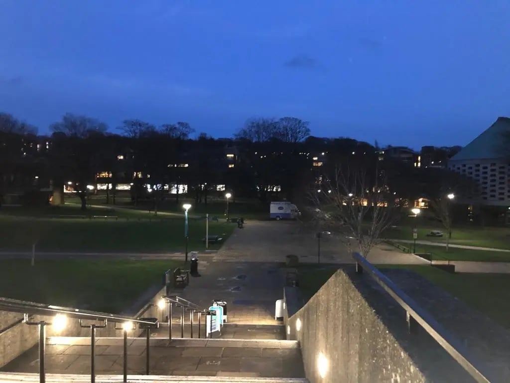 Campus der University of Sussex bei Nacht – Blick auf die beleuchteten Gebäude und Wege der Universität.