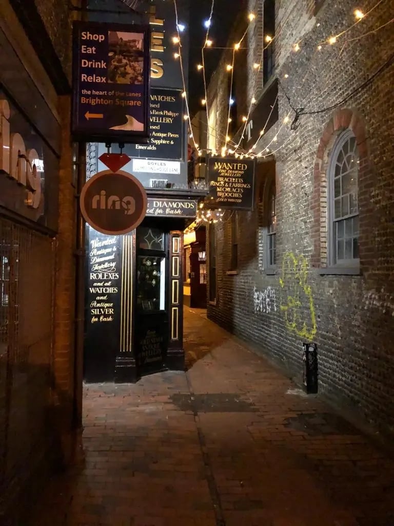 Schmale Gasse in Brighton mit Lichtern und kleinen Geschäften.