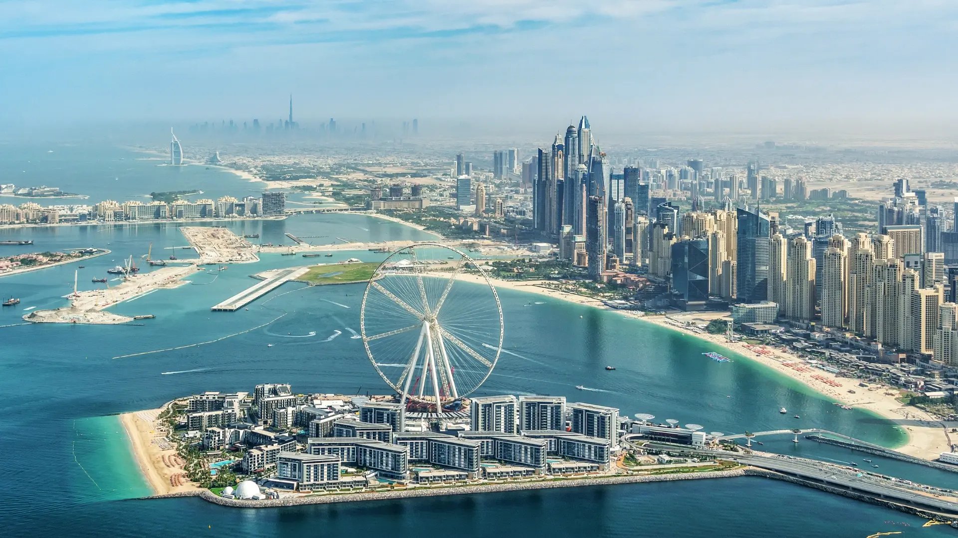 Luftaufnahme von Dubai mit dem Riesenrad Ain Dubai auf Bluewaters Island, der Skyline und der Küstenlinie mit Stränden und Hochhäusern..