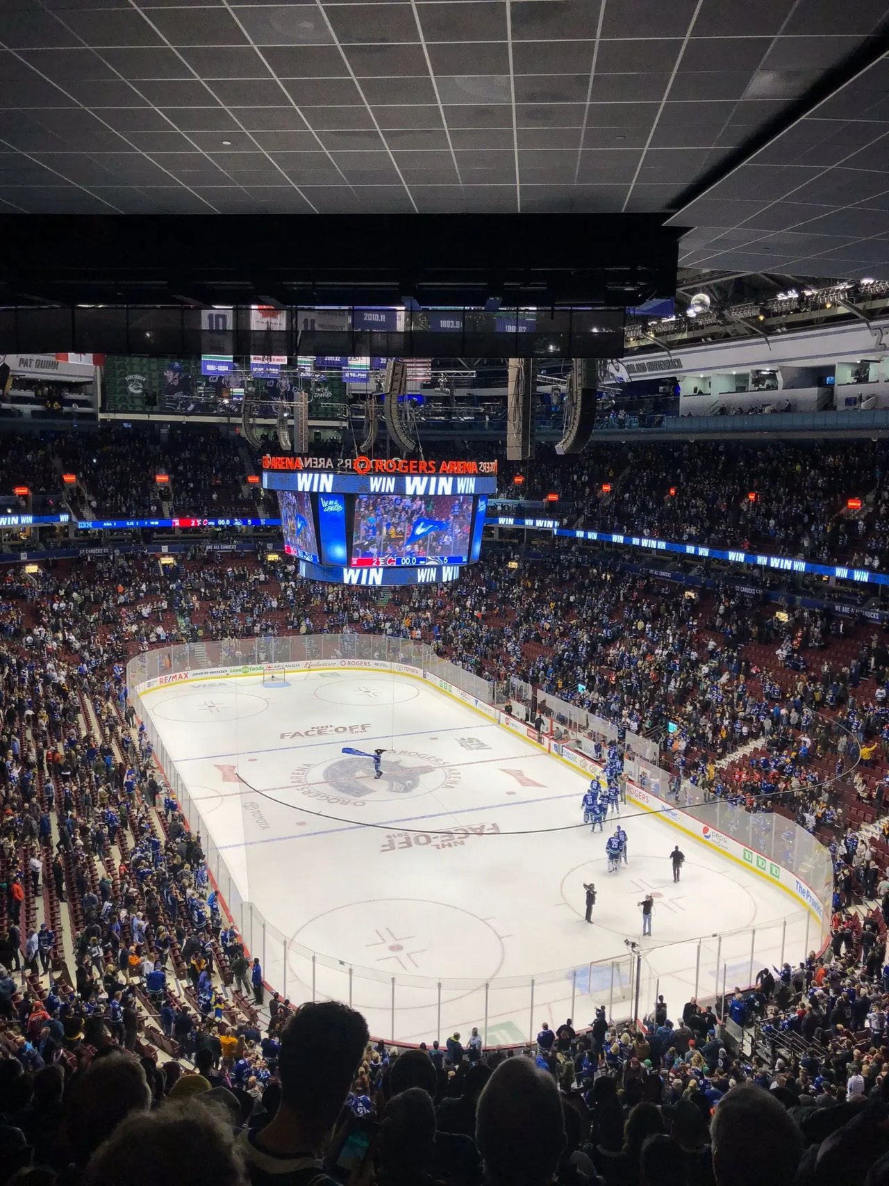 Innenansicht eines Stadions während eines Eishockeyspiels mit jubelnden Fans.