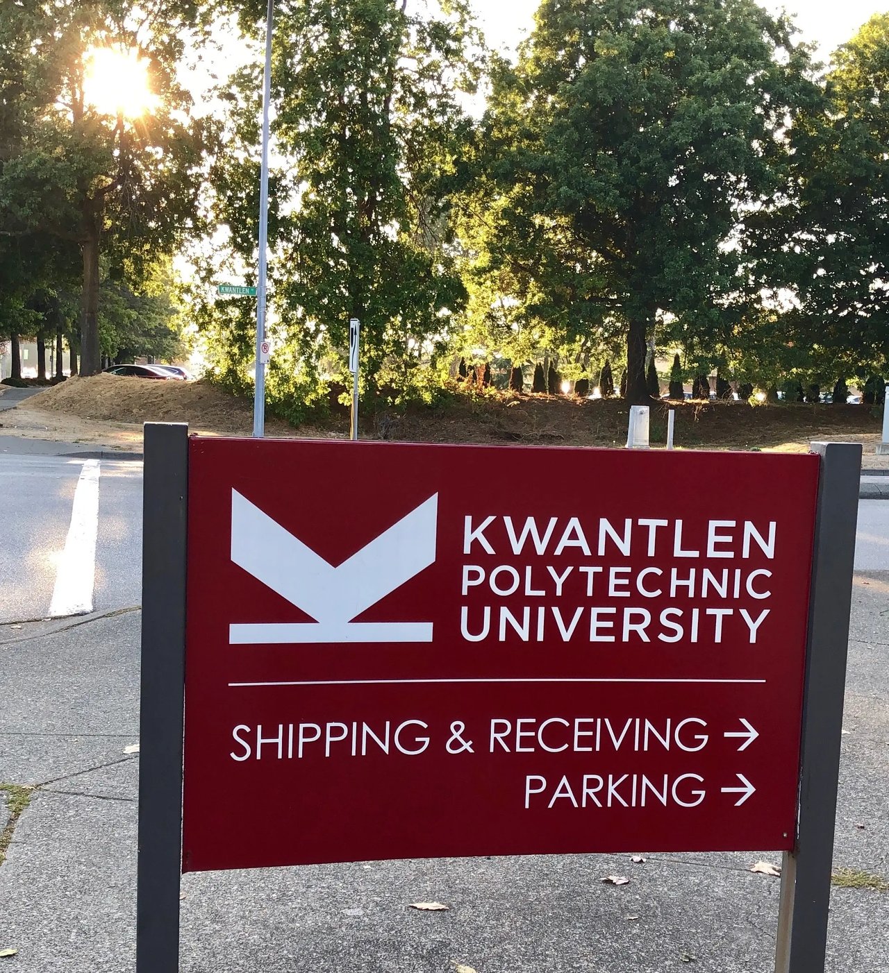 Rotes Schild der Kwantlen Polytechnic University mit Hinweisen zu verschiedenen Bereichen auf dem Campus.