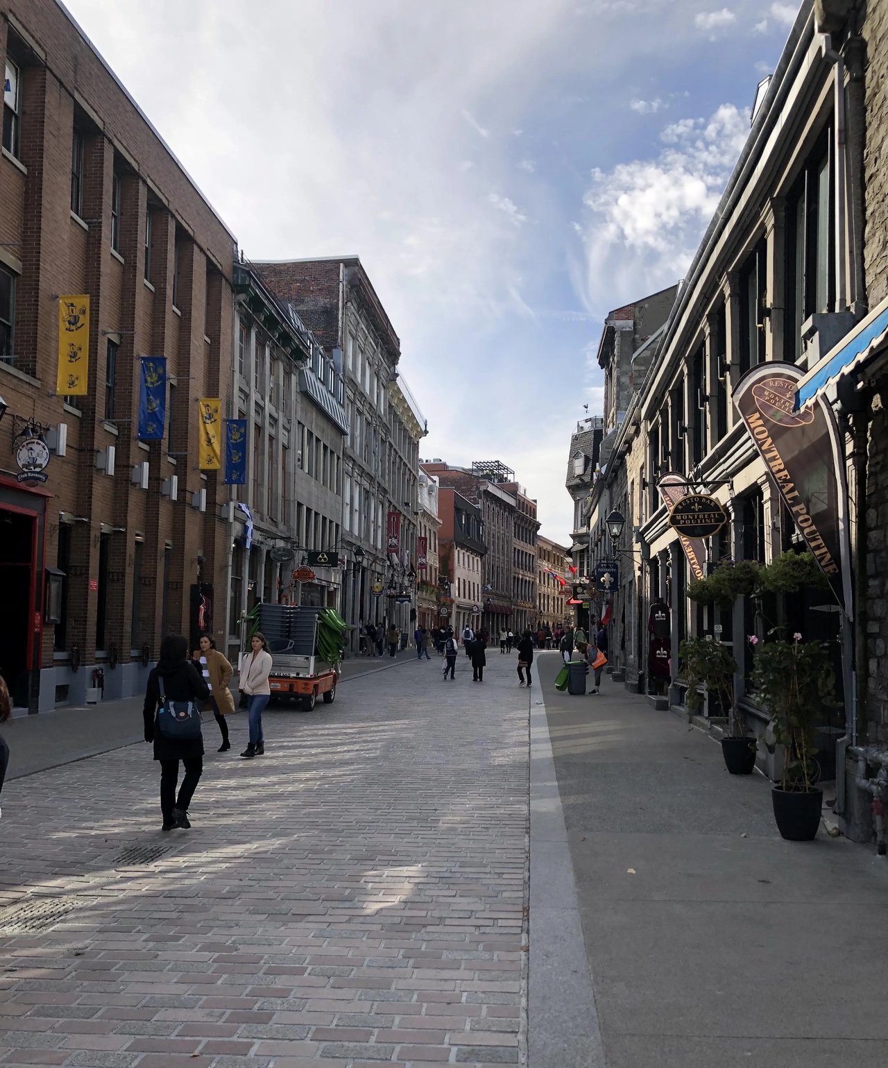 Belebte Straße in der Altstadt von Montreal mit historischen Gebäuden.