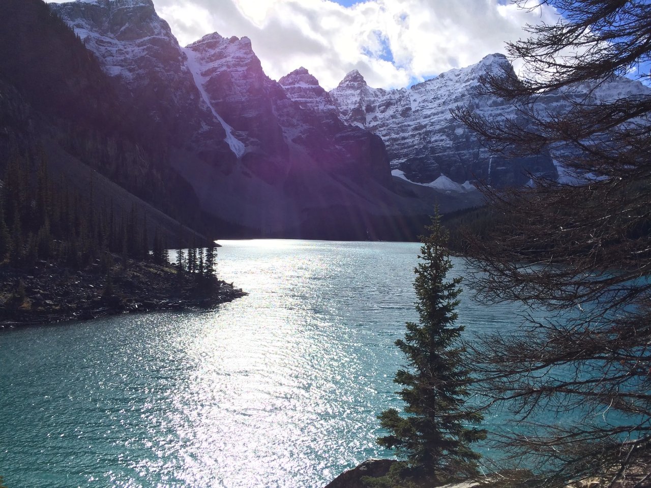 Malerischer Blick auf einen glitzernden See, umgeben von schneebedeckten Bergen in Kanada.