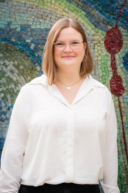 Kimberly Schäfer, Student Advisor & University Relations Manager bei IEC Online, lächelt in die Kamera vor einer bunten Mosaikwand. Kimberly Schäfer, Student Advisor & University Relations Manager bei IEC Online, lächelt in die Kamera vor einer bunten Mosaikwand.