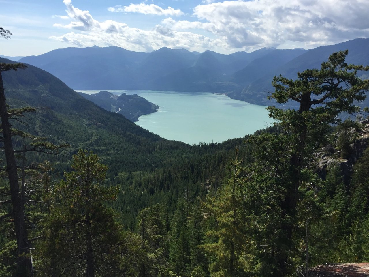 Aussicht auf einen See in British Columbia, umgeben von Wald und Bergen.