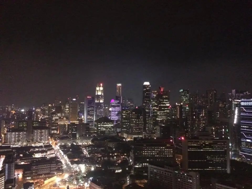 Aussicht auf die Skyline von Singapur bei Nacht, aufgenommen von einem Rooftop.