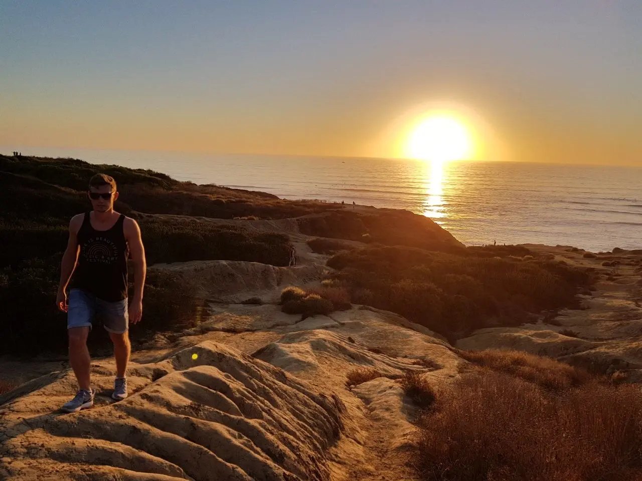 Sonnenuntergang an der kalifornischen Küste, ein Student der California State University Long Beach spaziert auf den Felsen mit Blick auf den Ozean.