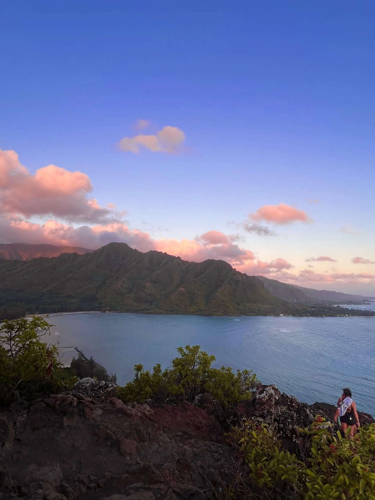 Atemberaubender Sonnenuntergang über den Küsten Hawaiis mit malerischen Bergen im Hintergrund.