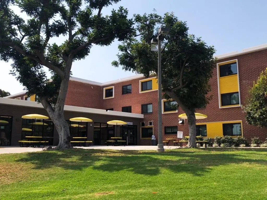 Wohnheim der California State University Long Beach, eingerahmt von gepflegten Grünflächen und schattenspendenden Bäumen.