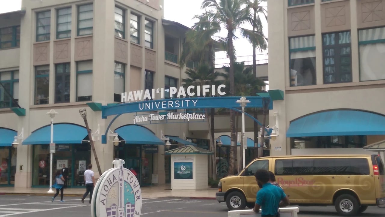Hawaii Pacific University Campusgebäude mit sichtbarem Schriftzug und Palmen im Vordergrund.