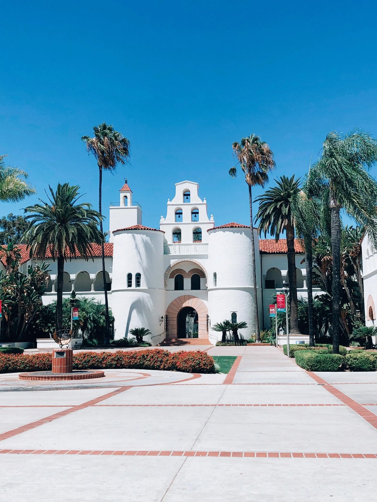 Gebäude mit weißem Putz und Palmen auf dem Campus der San Diego State University.
