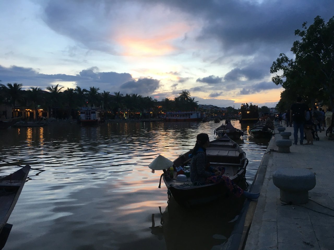 Ein romantischer Fluss mit Booten bei Sonnenuntergang in Hoi An, Vietnam.