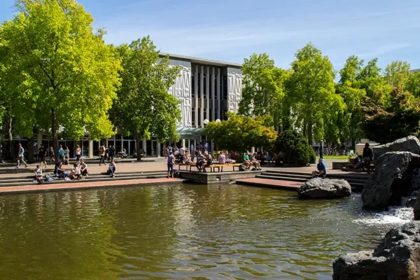 Campusgelände der University of Victoria mit Teich und Studierenden im Sommer.